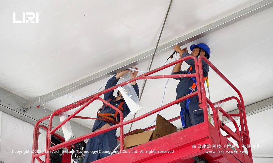 Liri workers installing PVC ceiling cables inside a Canton Fair temporary tent