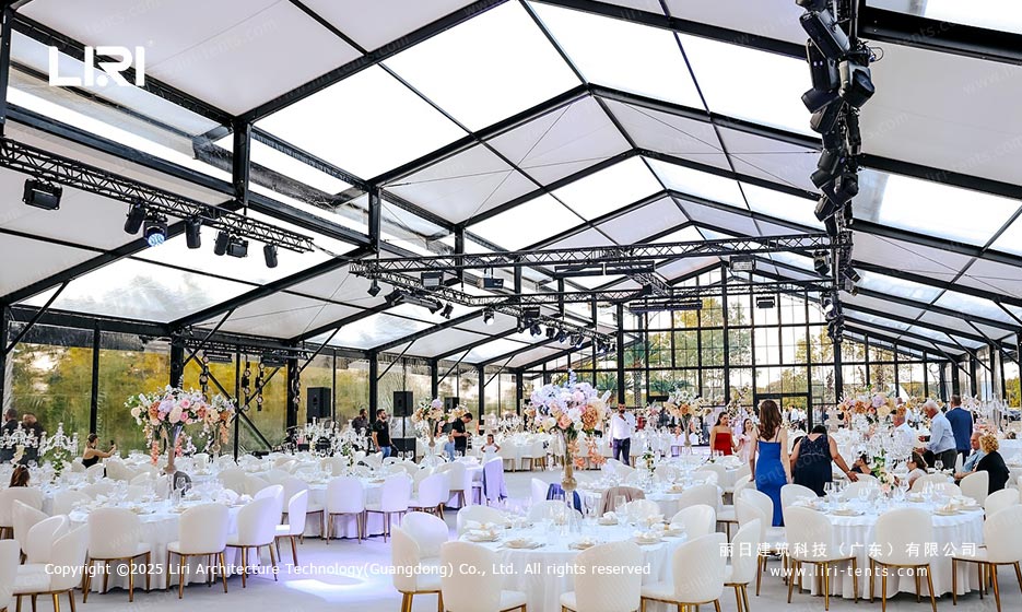 Orangery tent banquet interior with stage lighting and round tables