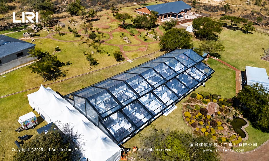 Orangery tent outdoor event aerial view with transparent roof and garden setting
