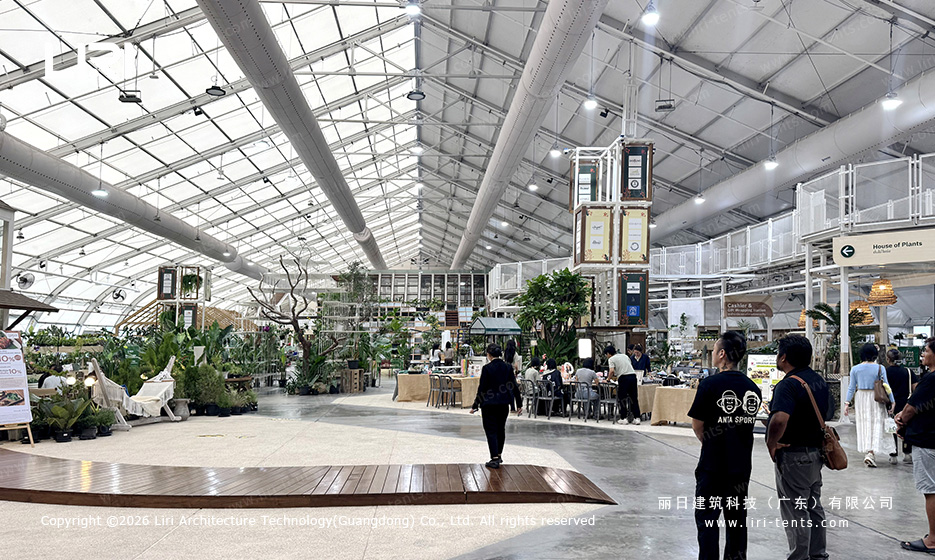 Transparent roof aluminum tent interior used as an indoor plant market and dining space
