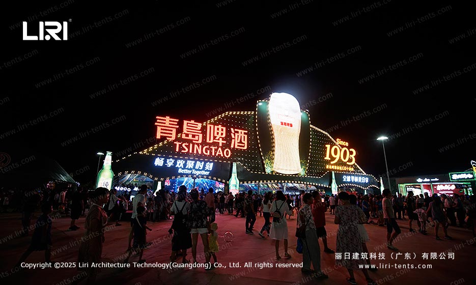 Branded Tsingtao beer festival tent entrance at night with visitor traffic