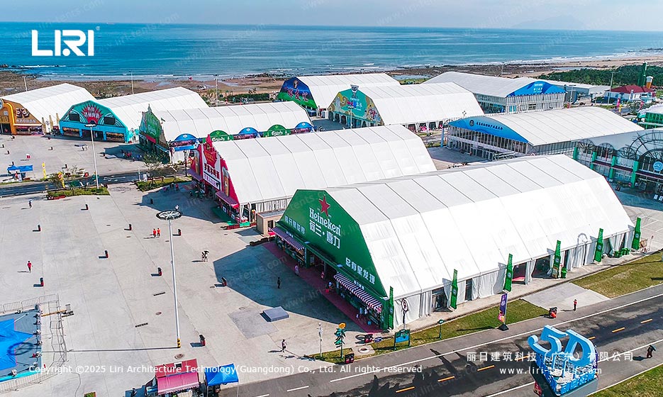Multiple beer festival tents with unified white roof layout and branded entrances