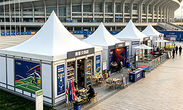 Modular pagoda tents with retail counters outside a stadium