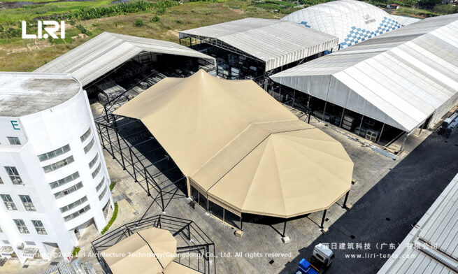 Aerial view of a beige high peak mixed tent with a polygon end and open sides