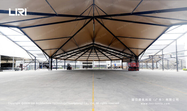 High peak mixed tent interior with dark roof framing and a wide open floor